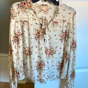 A flower covered blouse with a tie at neckline